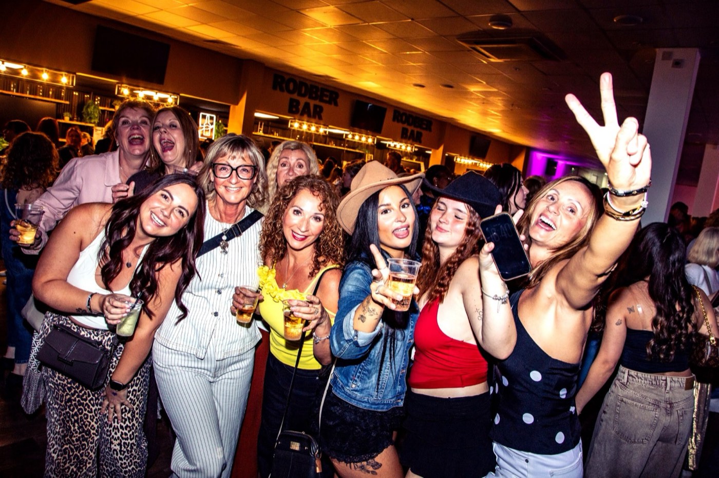 A group of friends posing together, drinks in hand