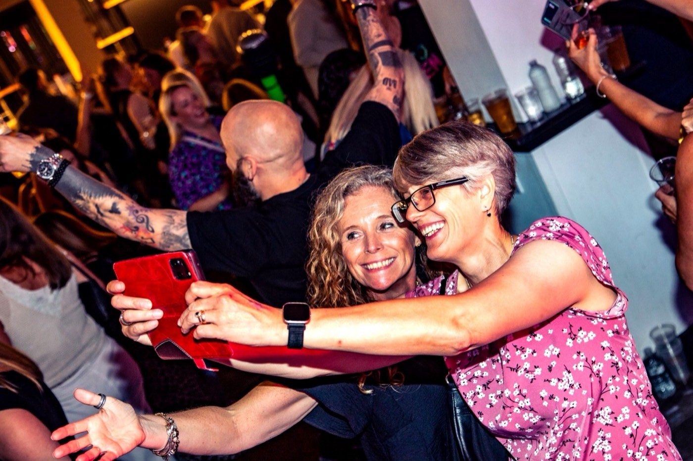 Two friends hugging and laughing on the dancefloor